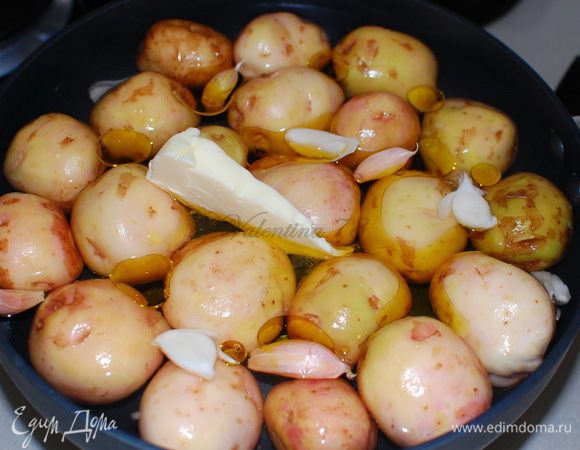 Хорошо вымыла картофель, сложила в сковороду (тефлоновая или чугунная),не плотно.
Залила бульон на 3/4 картофеля,добавила оливковое масло,сливочное масло,чеснок и соль. 