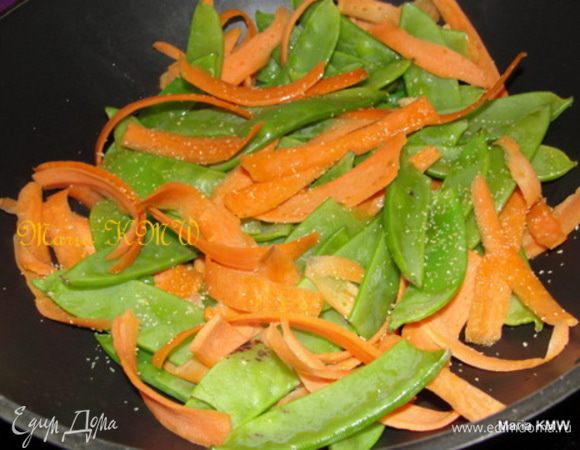 Морковь чистим, режем картофельным ножом на длинные, тонкие полоски.  
Горошек моем, обсушиваем.
Разогреваем раст. масло и на сильном огне обжариваем овощи несколько минут, тщательно помешивая, лучше всего на сковороде вок. Овощи должны слегка обжарится и остаться слегка хрустящими.
