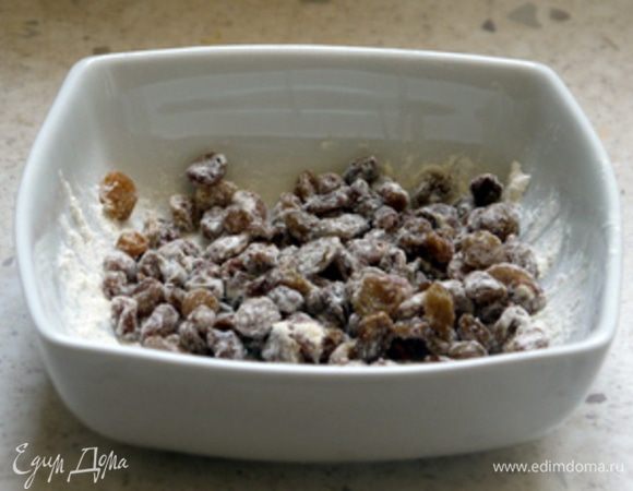 Отжать изюм и смешать его с небольшим количесвом муки.