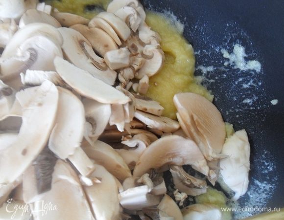 Тем временем шляпки тонко нарезать. В сковороде растопить сливочное масло, добавить грибы, немного обжарить их и всыпать муку. Хорошо перемешать.
