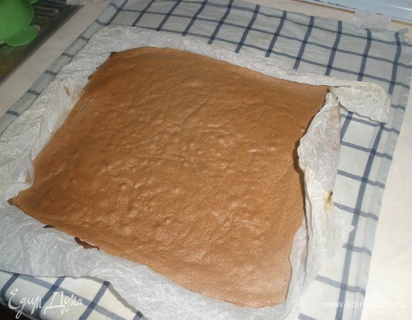 Горячий бисквит выкладываем вместе с бумагой на влажное кухонное полотенце