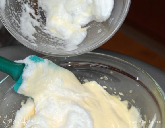 Осторожно ввести в желтки взбитые белки. Аккуратно перемешать лопаточкой движениями снизу вверх. 