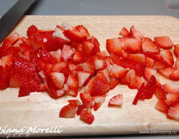 Клубнику вымыть и хорошо обсушить, порезать на мелкие кусочки, оставив часть ягод для украшения. 