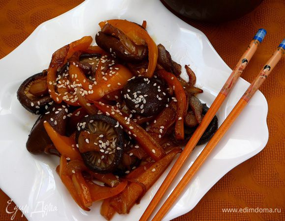 Огонь уменьшить и жарить 5-7 минут, периодически помешивая. Добавить соевый соус и красный жгучий перец. Перед подачей посыпать кунжутными семечками.