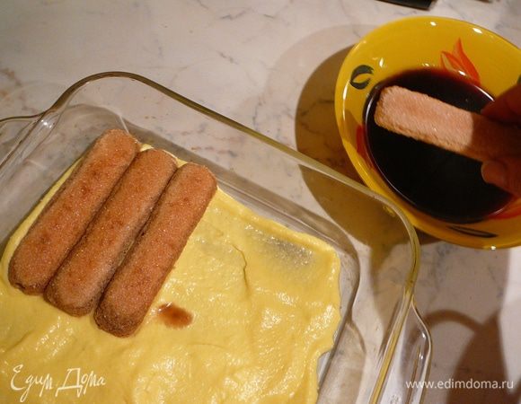 Берем по одному печенье и быстро обмакиваем  в кофе, укладываем в форму плотным слоем.