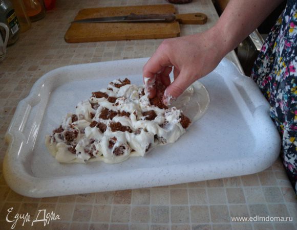 Собираем рыбку. Мокаем каждый кубик в крем и выкладываем на блюдо (поднос). Просто перемешать крем с кубиками нельзя, получится каша и торт не будет держать форму. 