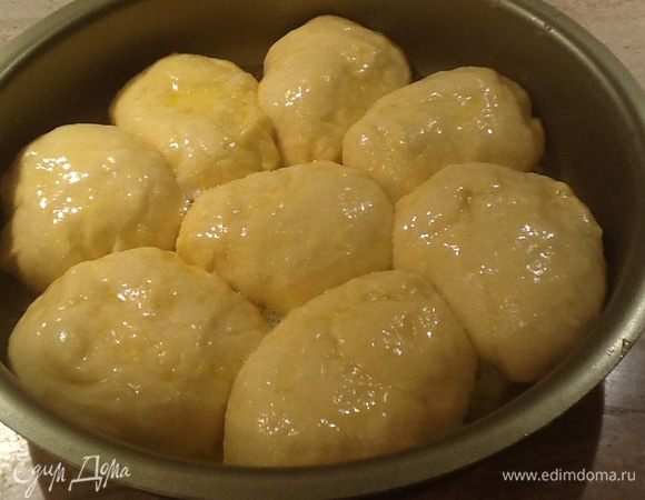 100г сливочного масла растопить.Каждую булочку обмакнуть в него и выложить в форму для выпечки плотно друг к другу. Поверхность пирога смазать яйцом.
Выпекать в предварительно разогретой духовке до 180 25-30 минут.