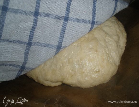 Еще раз обмять. Скатать в шар и выложить на противень, застеленный пергаментом. Накрыть полтенцем и оставить на 15 минут. Придать тесту форму каравая. Тем временем включить духовку на 200 градусов. 