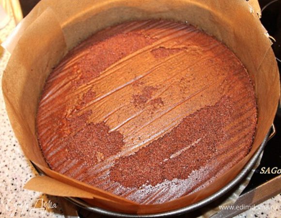 Укладываем бисквит в разъёмную форму, застеленную пергаментом. Бока выстилаем лентой из пергамента, чтобы в последствие получились ровные края торта. Смешиваем ингредиенты пропитки. Кисточкой пропитываем всю поверхность бисквита. Делать это удобнее, когда бисквит уже уложен в форму, потому что, пропитавшись, он увеличивается в размере в полтора раза (в основном в высоту, но и в ширину тоже немного).
