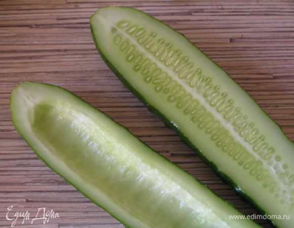 Огурцы разрезать вдоль пополам, с помощью чайной ложки вынуть серединку, 