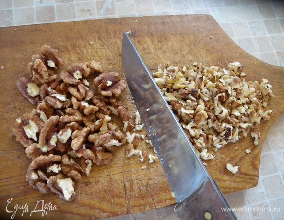 Грильяж. В сотейник всыпать сахар и налить воду. Поставить на маленький огонь и не помешивать минут так 20. Почистить орехи. Порезать не сильно мелко. 
