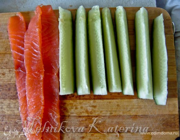 Сперва огурец необходимо разрезать на восемь равных частей. Подготовить полоски из лосося. 