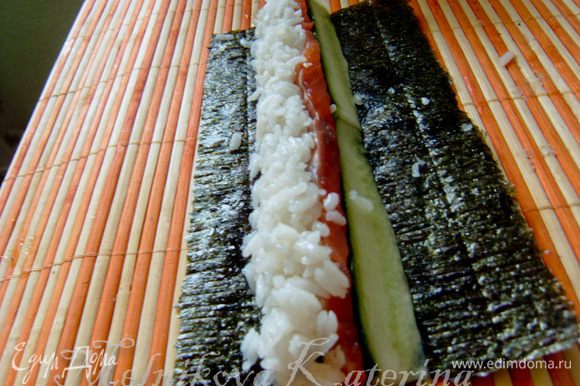 Далее горизонтально за лососем выложить небольшой слой риса.