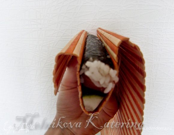 Затем нужно взять в руки ролл вместе с циновкой и на весу пальцами прижимать его, укрепляя сформированный сектор. 