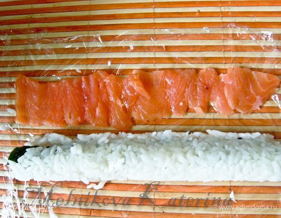 Затем выложите на пленку рыбу, нарезанную тонкими пластинками.