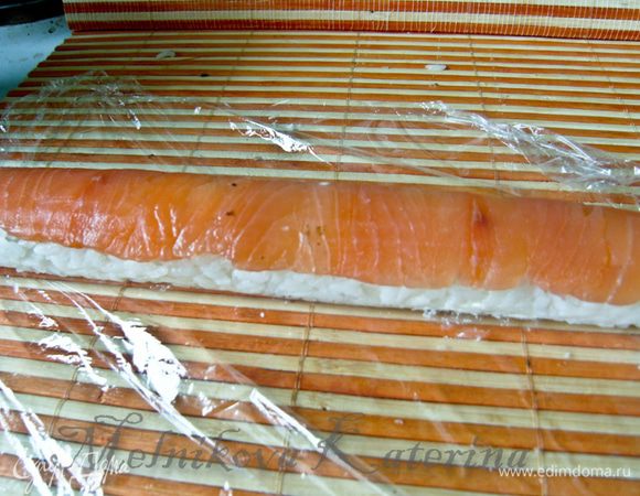 Еще раз сверните ролл с циновкой, «пройдясь» по рыбе, отогните пищевую пленку. Получится вот такой красивый ролл без нори.