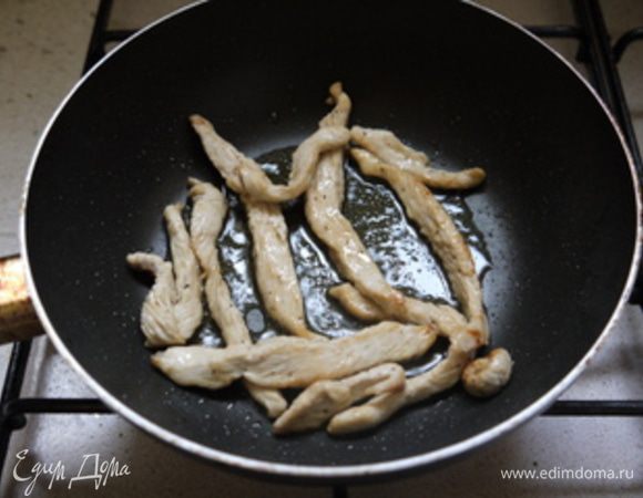 На оливковом масле на сковороде Tefal обжарить зубчик чеснока.Когда он зарумянится, достать его из сковороды и поместить в неё полоски из грудки.Обжарить несколько минут.(т.к.полоски тонкие,они готовятся моментально).