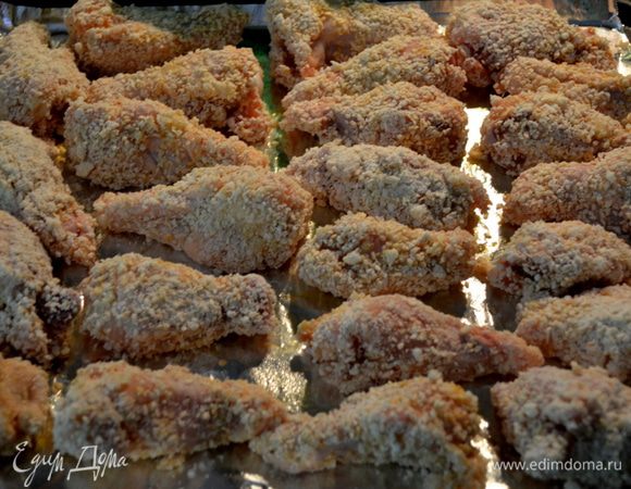 Каждое крылышко обвалять в панировке и выкладывать на противень.Сбрызнуть раст.маслом.