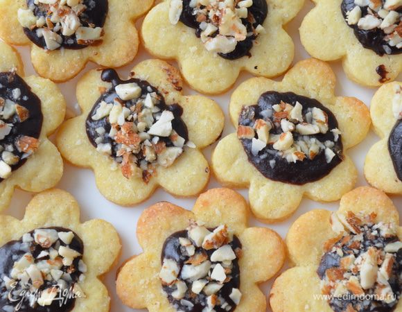 Печенье остудить. В центр каждой печенюшки выложить пол чайной ложки горячей глазури, посыпать немного рубленных орехов на глазурь. Охладить и есть!