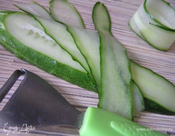 Огурцы разрезать вдоль пополам, уложить срезом вниз и с помощью овощечистки срезать с огурца несколько полосочек (до семян). Каждую полоску завернуть в ролл.