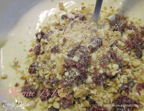 Муку смешать с разрыхлителем, добавить в яичную смесь. Добавить растительное масло, кипяток, измельченные орехи с вишней.