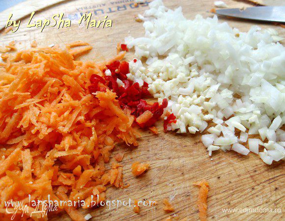 Первым делом надо отварить рис в соленной воде до состояния аль-денте, чтобы внутри была чуть твердая серединка и оставить его остывать. Лук, чеснок и перец чили мелко нашинковать. Морковь натереть на мелкой терке. Попробуйте немножко перчика чили на язык, если он не очень острый можно его положить чуть больше, если очень - чуть меньше. Помидор надо выбрать более плотный, не водянистый. Сделаем надрез крестом на его "макушке" и ошпарим кипятком.