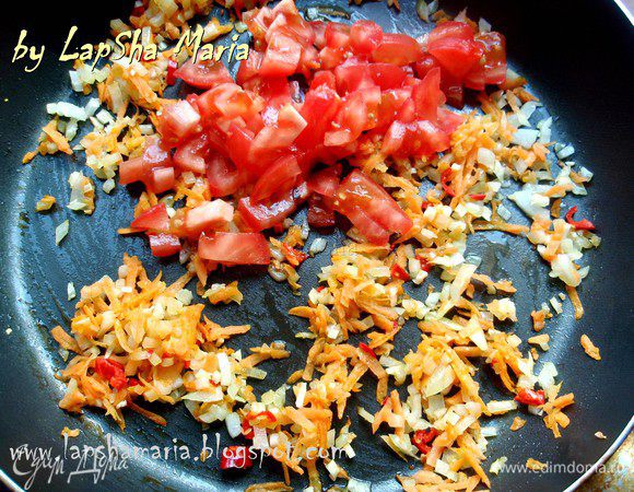 На оливковом масле обжарим лук, чеснок и перец чили до прозрачности лука, минуты 2-3. Пока можно снять кожицу с помидора и нарезать его на небольшие кубики. Добавим их в сковороду и ещё немного потомим вместе, примерно минут 5. Дадим немного остыть.