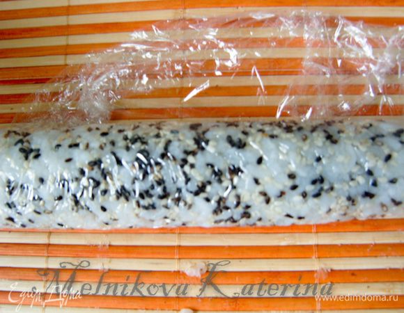 Завернуть нори в ролл при помощи коврика для суши. Затем отогнуть пищевую пленку. 