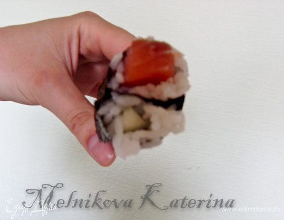 Затем сложить обе части и сформировать из них круглый ролл при помощи коврика для суши. 