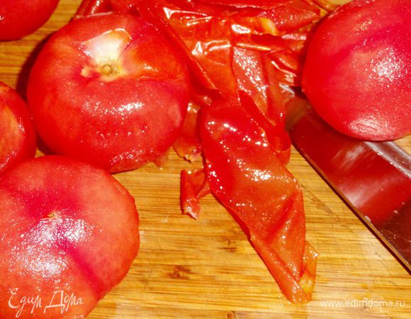 Пока рис варится, обдайте помидоры кипятком и снимите кожу.