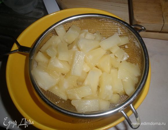 Ананасы откинуть на сито и дать соку стечь. Порезать на маленькие куски. 