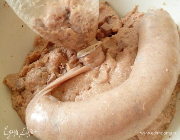 приступаем к формовке колбасок.Берем кишку,завязываем на конце дважды узелком и заполняем фаршем.Я использую воронку из пластиковой бутылки.Оболочку одеваем на горлышко и закрепляем резиночкой или ниткой.Фарш набиваем не совсем плотно,что бы колбаски не лопались.Делаем колбаски длиной 12-15см,опять завязываем конец кишки двойным узелком.Искусственную оболочку узелком завязать трудно,поэтому завязываем нитками.