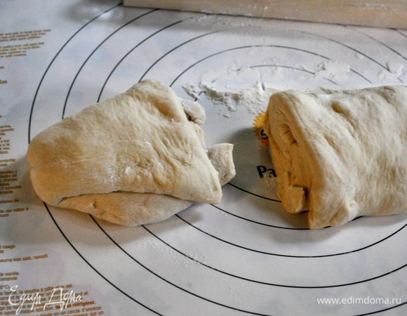 Готовое тесто выкладываем на поверхность, припылим мукой, делим на 2 части.