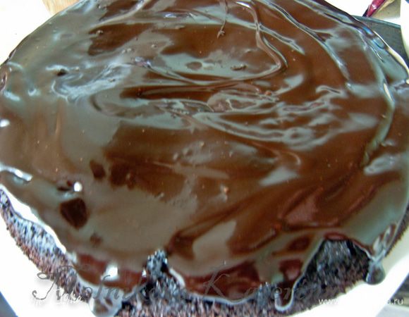 Вынуть из духовки пирог, освободить от формы. Дать пирогу немного остыть. Затем залить всю поверхность пирога шоколадной глазурью.