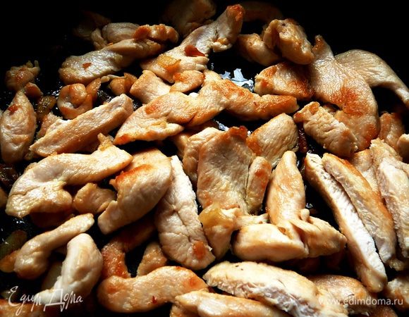 Куриное филе нарезать тонкими полосками и обжарить с чесноком на оливковом масле 5-7 минут.