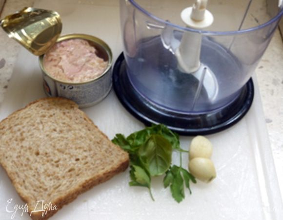 В блендере перемешать тунца с хлебом, порезанным на кусочки, чесноком, базиликом и петрушкой.