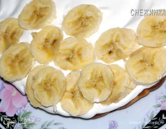 На блюдо кладем один корж, покрываем кремом. На крем раскладываем банан.