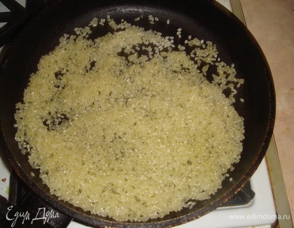 Обжариваем рис на сухой сковороде до впитывания масла.
