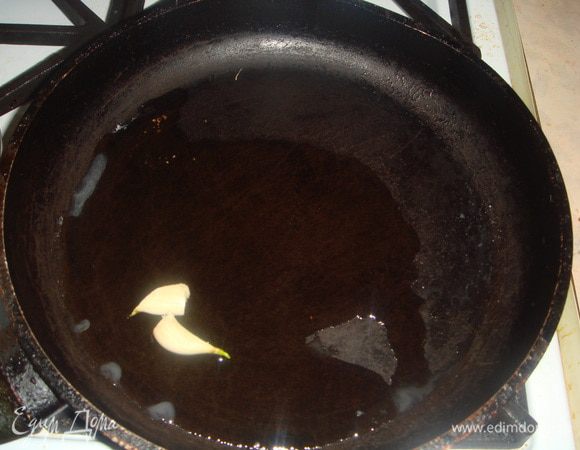 На сковороду наливаем оливковое масло и кладем 2 зубчика чеснока.