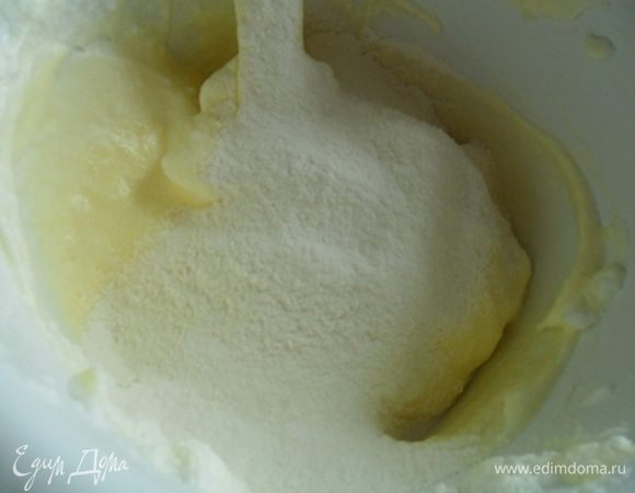 Желтки влить к белкам и аккуратно перемешать от краев к центру. Добавить просеянную муку.
