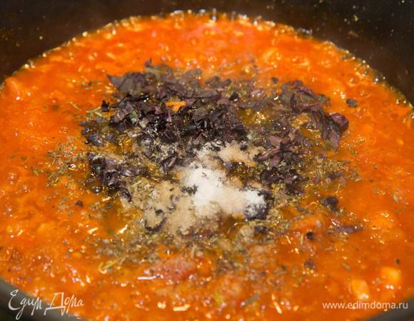 Добавляем в соус травы, соль, перец, свежий базилик. Доводим до кипения и выключаем. Оставляем остывать.