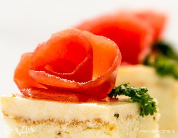 Берем вторую часть коржа и выкладываем поверх куриного мусса , так , чтоб тонкий слой сырного мусса, который на нем уже застыл, оказался сверху. Убираем в холодильник и оставляем еще на пару часов, до полного застывания. Вынимаем из формы, легонько потянув за края пленки. Режем на нужные нам куски и украшаем. Для этого нам понадобиться счищенная с помидора кожура. Просто закручивая ее, можно сформировать симпатичные розочки и выложить их сверху, а из петрушки можно выложить листочки.