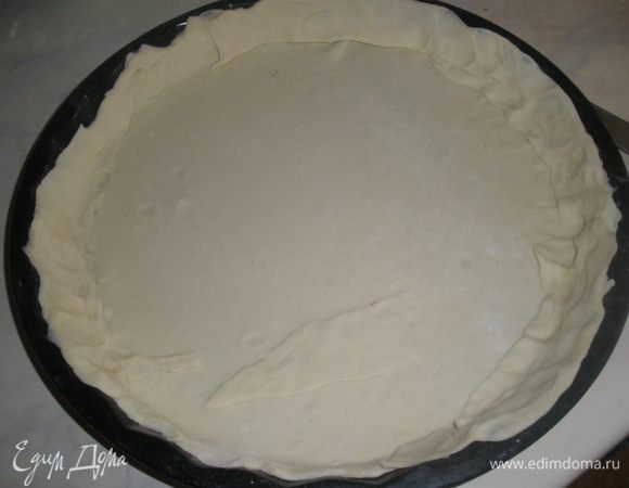 Раскатать  тесто и переложить его в форму для выпечки диаметром 28 см. Сделать высокие бортики, а излишки обрезать. 