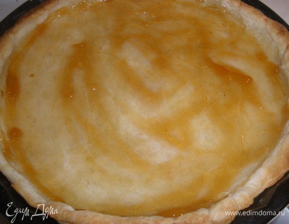 Достать основу для пирога, убрать бумагу с горохом, немного остудить и смазать ее джемом. 