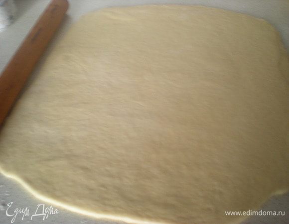 Затем достаем тесто из миски на подпылённый мукой стол,срезом вверх.Раскатываем в четырёх направлениях,начиная с середины,там где вырезан крест.Но у меня к утру уже крест не прорисовывался,а получился огроменный шар,но примерно я догадалась где должна быть середина.