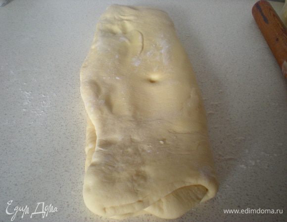 Достаем тесто,перекладываем на стол,короткой стороной к себе.Стол можно немного подпылить мукой.