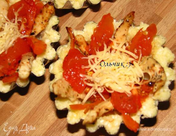 На дно тарталетки выкладываем ложку заливки, затем кусочки курицы, морковки, помидора. Перед тем как укладывать кусочки помидора, снимем с них кожицу. Присыпаем сыром.