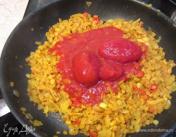 Выложите помидоры вместе с соком в карри. Разомните помидоры вилкой.