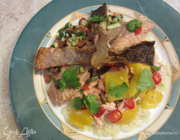 Теперь сервируем блюдо.
Выложите три-четыре столовых ложки кускуса посередине тарелки. Положите сверху разломанные кусочки семги, а затем целый кусок. Выложите часть перцев вместе с луком. Полейте соком из блюда, где готовилась рыба. Не жалейте сока, т.к. кускус замечательно впитает его. Сверху выложите кусочки хрустящей кожи и положите сальсу.