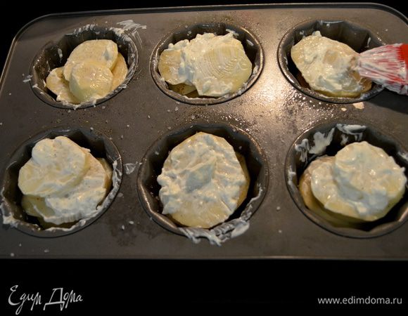 Разогреть духовку до 200°C. Выложить картофель, нарезанный пластинками, посолить и поперчить каждый слой. Смазать сметаной или сливками сверху. Посыпать сыром.